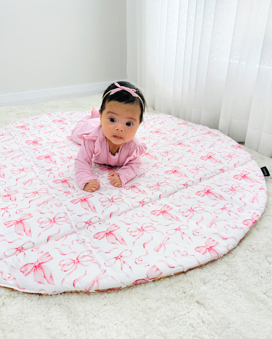 the prettiest little baby girl and her custom made play mat with pretty bows made by harmony j.
