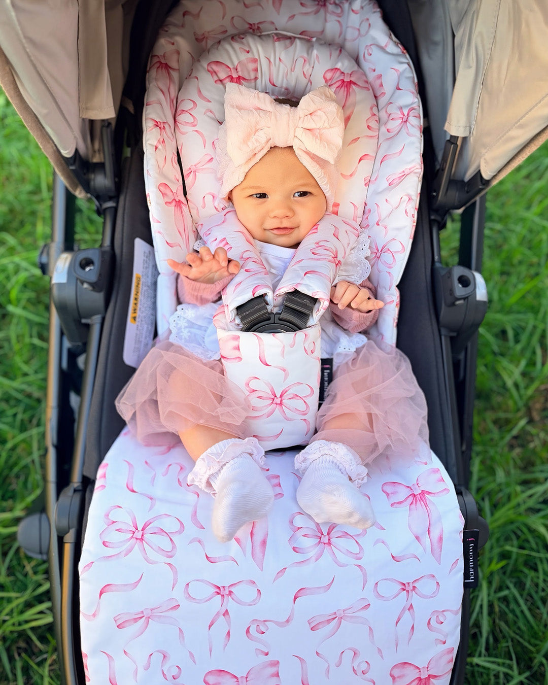Adorable little girl and her pram liner and accessories made by harmony j. Pretty little bows.