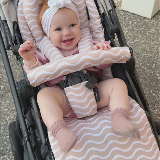 Little girl happy in here Uppababy Vista V2 pram with her pram liner and accessories.