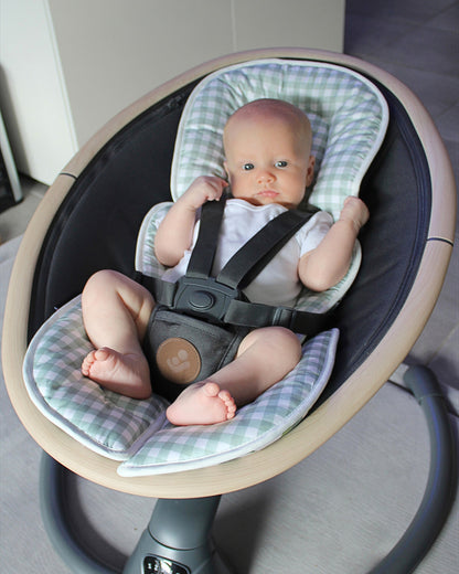 Baby boy with his newborn insert, looking comfortable in the baby swing.